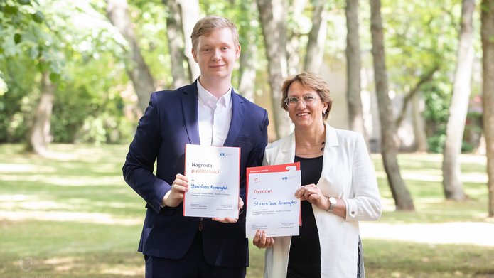 Nagrodzeni studenci pozujący do zdjęcia z dyplomami