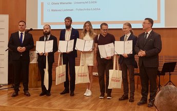 Grupa osób stojąca na scenie