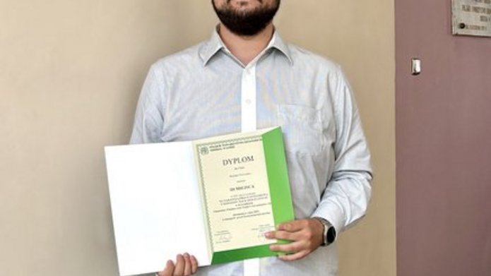 Osoba trzymająca w ręce dyplom