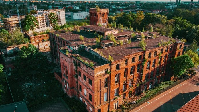 Ruina dawnej fabryki włókienniczej otoczona budowami nowych obiektów mieszkalnych