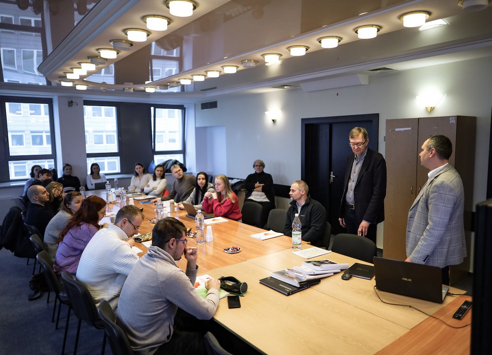 Osoby dyskutujące przy dużym stole