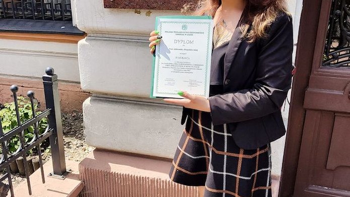 osoba trzymająca w rękach dyplom